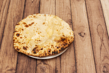 Typical middle eastern cheese naan bread on wooden table