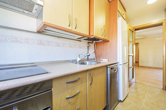 Kitchen With Wooden Furniture And Mismatched Appliances