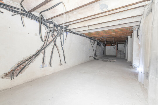 Raw underground premises without windows with electrical pre-installation with corrugated pipes and cement floors