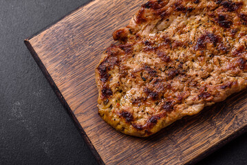 Delicious juicy grilled pork steak with spices and herbs