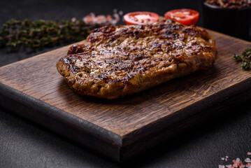 Delicious juicy grilled pork steak with spices and herbs