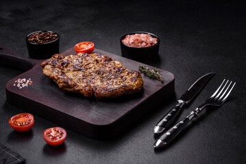 Delicious juicy grilled pork steak with spices and herbs