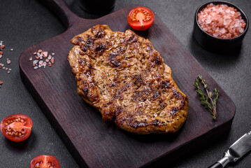 Delicious juicy grilled pork steak with spices and herbs