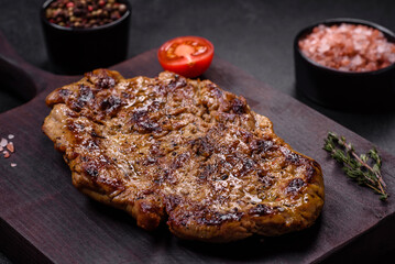 Delicious juicy grilled pork steak with spices and herbs