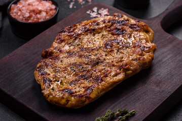 Delicious juicy grilled pork steak with spices and herbs