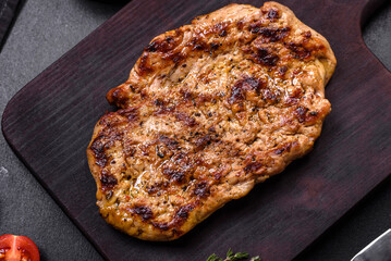 Delicious juicy grilled pork steak with spices and herbs