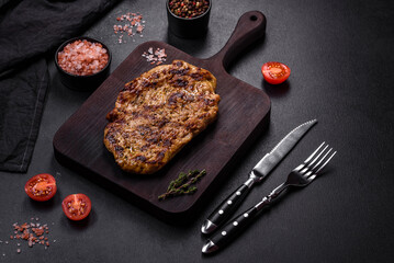 Delicious juicy grilled pork steak with spices and herbs