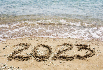 Happy New Year 2023 on the sea beach, 2023 write on sand and sea waves