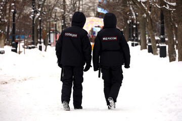 Russian police officers patrol a city street in Moscow on background of New Year decorations....