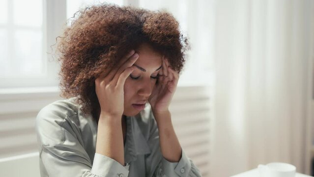 Closeup of woman having headache while working in office, overworked person