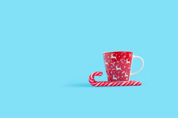 Minimal New year and Christmas concept with candy cane and coffee mug.