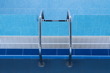 Descent to a large swimming pool. Empty swimming pool with descent down. Staircase leading to the...