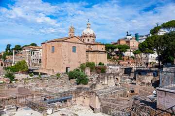Obraz premium Italy Rome. Excavations in the center of Rome near the Colosseum.Well preserved buildings and artifacts on a sunny summer day against a blue sky.