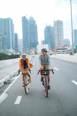 A young couple riding their bikes together in the city.