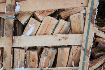 Fototapeta na wymiar Wooden box with firewood. Chopped and hand-folded in a crate for sale or for storage in a cottage. transport by pallet truck.