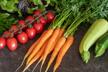 Farm vegetables (tomatoes, carrots, lettuce) on the table