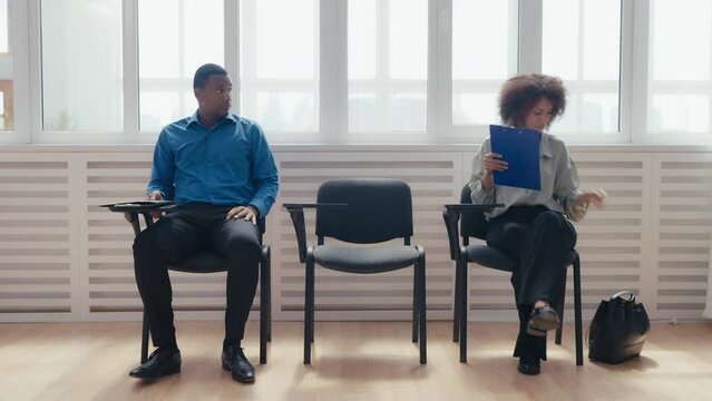 Nervous African American man and woman waiting for bank or job interview