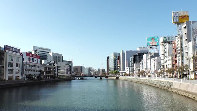 HAKATA, FUKUOKA, JAPAN - NOVEMBER 2022 : Time lapse shot of NAKASU area in daytime. Red-light district which exists between the sandbank of the Naka River and the Hakata River.