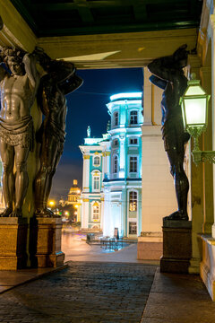 Evening view of the black sculptures of Atlanteans at the entrance to the Hermitage in St. Petersburg