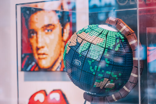 31 July 2022, Koln, Germany: Lego shop showcase with globe model and Elvis Presley portrait