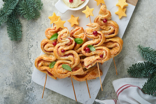 Christmas Or New Year Appetizer. Christmas Tree Shape Puff Pastry Buns With Cheese And Ham. Group Of Christmas Tree Shapes On Marble Stand. Festive Idea For Christmas Or New Year Dinner. Top View.