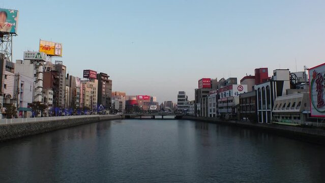 NAKASU, HAKATA, FUKUOKA, JAPAN - NOV 2022 : View of NAKASU area in sunset. Red-light district which exists between the sandbank of the Naka River and the Hakata River. Time lapse shot, dusk to night.