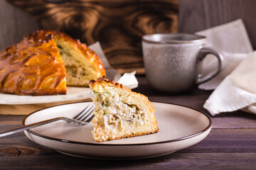 A piece of savory pie with chicken, potatoes and rice on a plate. Homemade pastries © elenarui