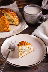 A piece of kurnik pie with chicken, potatoes and rice on a plate. Homemade pastries. Vertical view © elenarui