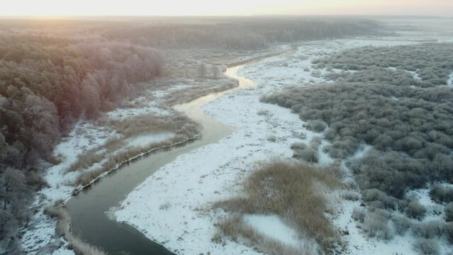small river near the forest in winter drone flight