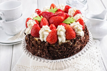 Traditional German strawberry cheese cake with fresh fruits and chocolate crumbles served as close-up on a cake plate