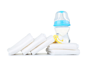 Baby diapers with pacifier and bottle of water isolated on white background