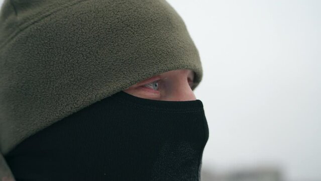 Close-up portrait of a soldier in a winter hat and balaclava. war in winter. performing a combat mission at sub-zero temperatures