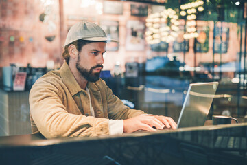 young hipster bearded man using laptop in a cafe