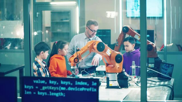 Robotics lab with kids and a male tutor. Technology, school education concept.