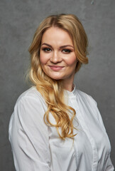 portrait of a young beautiful blonde model, isolated on gray background