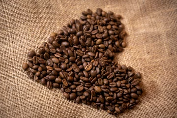 Tuinposter Koffiebar grains de cafés en forme de coeur sur une toile de jute