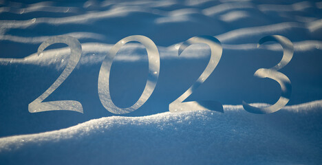 new year 2023 - winter snow background - snow covered surface and artistic bokeh