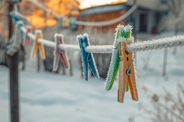 Clothes pegs hung on a clothesline in winter. Pegs for clothes with ice crystals in winter on a...