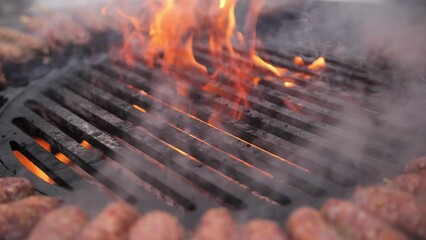 Turkish kebab is cooked on a circular grill in the open air. Close-up of the grill fire while cooking meat on skewers on the grill.