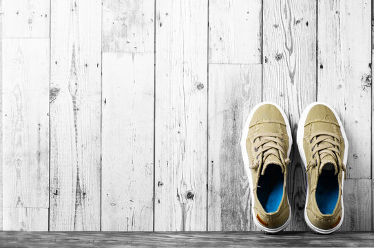 retro hipster sneakers with white laces stand against a gray wall on the floor. Banner. Space for text.