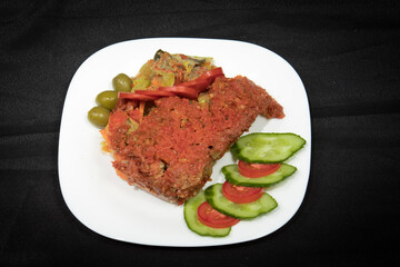 Potatoes and meat with vegetables in tomato sauce on a white plate