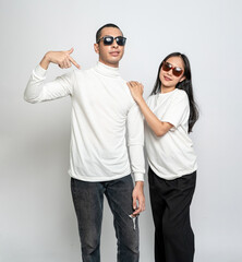 Young couple wearing white blank shirt and glasses doing a pose at the white background