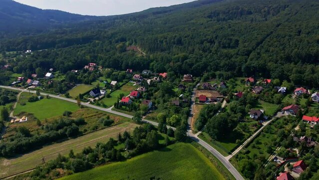 Aerial view of countryside road with moving cars, Weekend road trip to suburban area, Beatiful nature background with mountains and small village