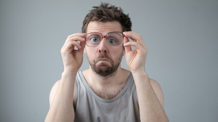 Surprised man in big glasses with WOW expression on gray backgound
