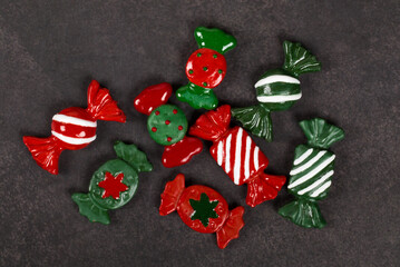 Christmas candies. Themed cute sweets covered with colored icing sugar. Dark gray background. Top view. 