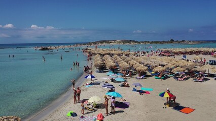 Menschen, die sich an sonnigen Sommertagen am berühmten rosafarbenen Korallenstrand von Elafonisi auf Kreta entspannen