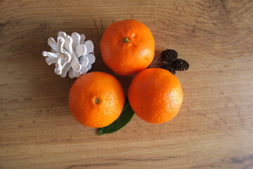Mandarin slices on a wooden table with a green leaf and gold beads