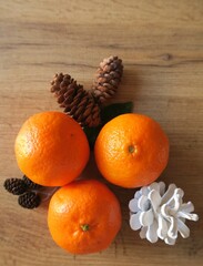 Mandarin slices on a wooden table with cones