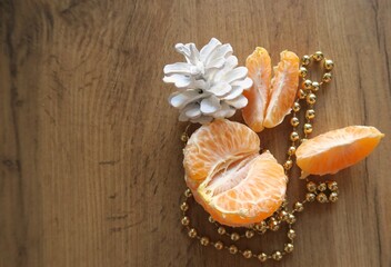 Mandarin slices on a wooden table with cones