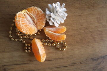 Mandarin slices on a wooden table with cones